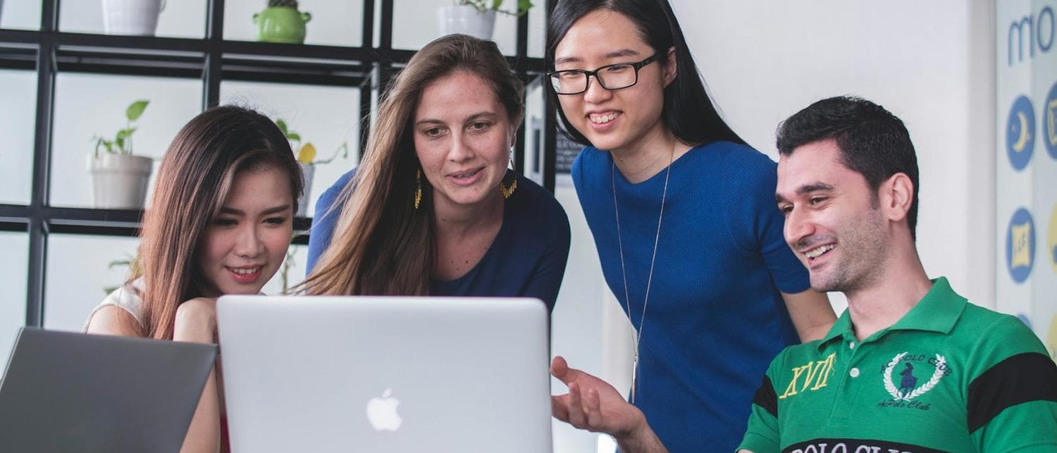 A team working together around a laptop